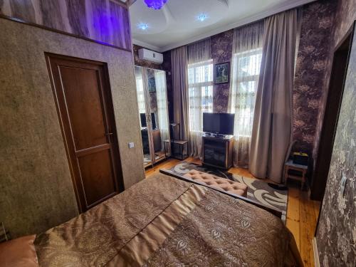 库塔伊西Hostel Sadu Kutaisi的一间卧室设有一张床、一台电视和窗户。