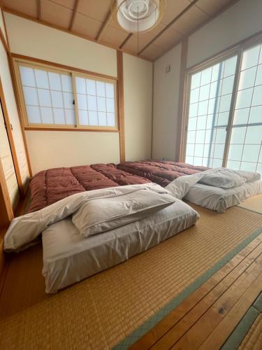 ShimotakaiFive Peaks Ryuoo的带2扇窗户的客房内的2张床
