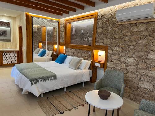 罗萨里奥港Hotel Rural Rosario Martin的一间卧室设有一张床和石墙