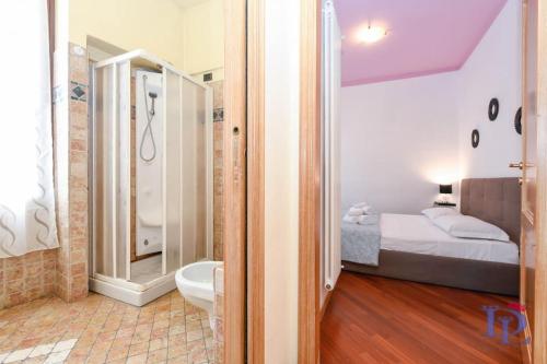 代森扎诺-德尔加达DesenzanoLoft Let It Be A Dream的一间卧室配有一张床,浴室设有淋浴。