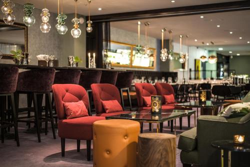 耶夫勒克拉利奥温恩酒店的一间设有红色椅子的餐厅和一间酒吧