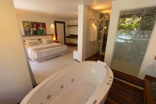 圣佩德罗-达阿尔德亚恩塞达达斯盖科斯旅馆的带浴缸的浴室和1间带1张床的卧室