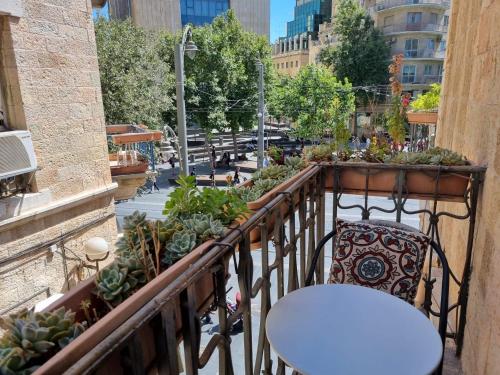 耶路撒冷耶路撒冷旅馆 的阳台配有桌子和椅子,还有一些植物