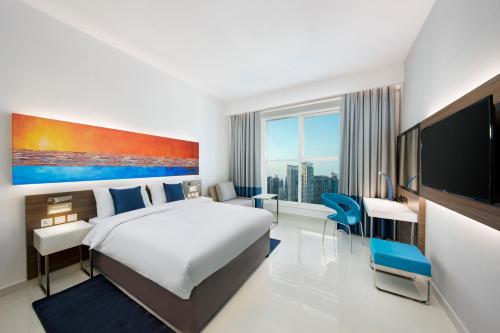 迪拜大都会商业湾酒店的配有一张床和一台平面电视的酒店客房