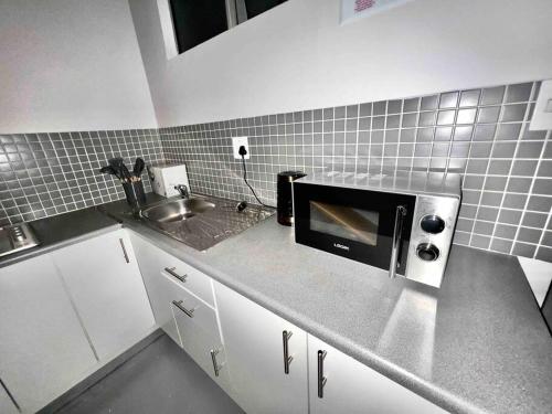 约翰内斯堡`Luxury Cosy City Apartment的厨房配有水槽和微波炉