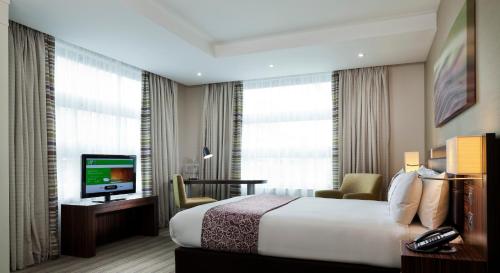 伦敦伦敦假日酒店 - 白教堂 的酒店客房,配有床和电视