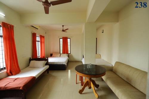 TripunnittaraArackal Tourist Home的客厅配有沙发和桌子