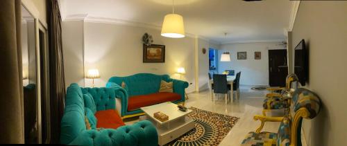 开罗Cozy in Giza 2 bedroom apartment的客厅配有蓝色的沙发和桌子