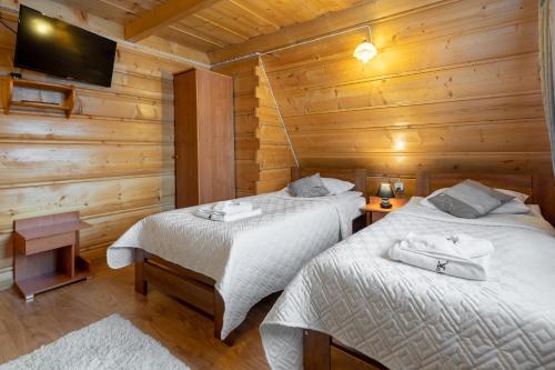 布泽吉Villa Kucówka的木墙客房的两张床