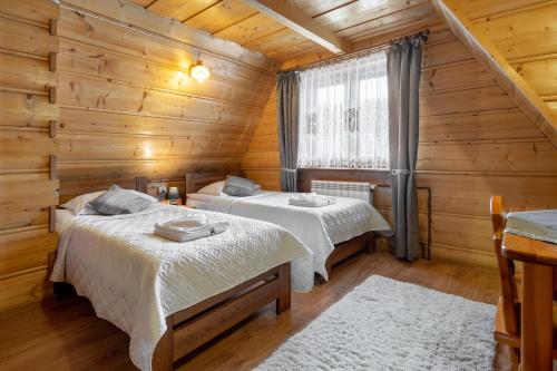 布泽吉Villa Kucówka的小木屋内一间卧室,配有两张床