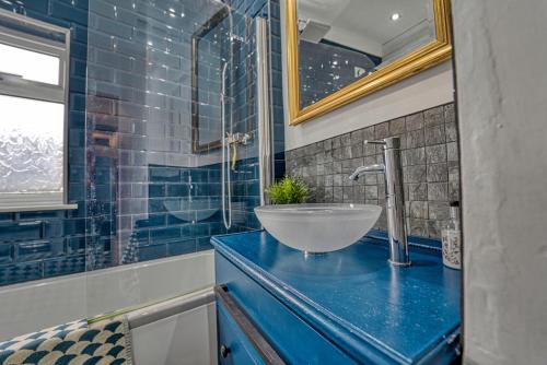莱斯特Guest Homes - Loughborough Road House的浴室设有蓝色的柜台上的碗水槽