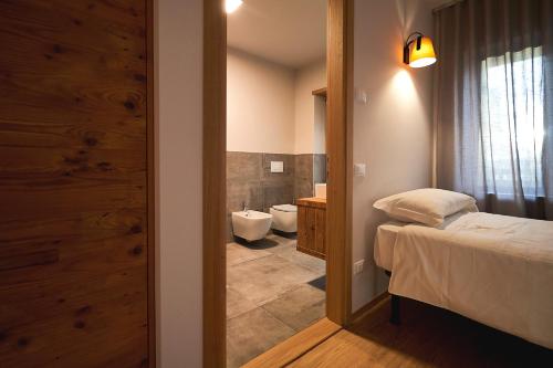 阿夏戈Hotel Ristorante Pennar的一间卧室配有一张床,浴室设有卫生间