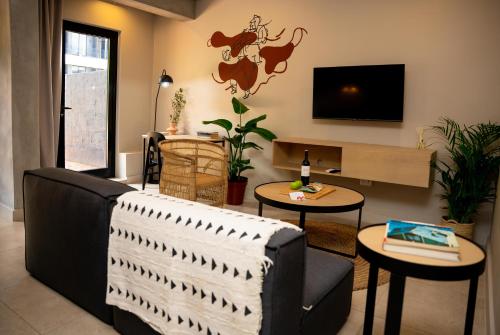 约翰内斯堡BlackBrick Sandton Two的客厅配有沙发、桌子和电视
