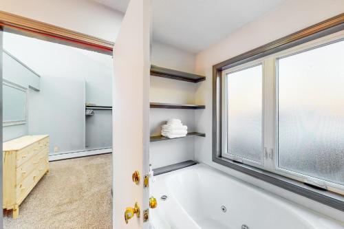 JayRiverbend Retreat的带浴缸的浴室和大窗户
