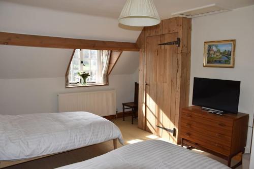 洛尔斯劳特Riverside Cottage的一间卧室配有两张床和一台平面电视