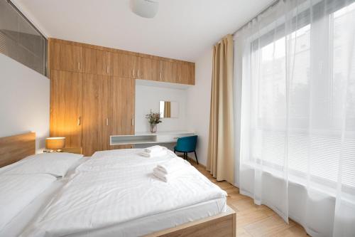 布拉迪斯拉发维尔戈公寓式酒店的卧室设有白色的床和大窗户