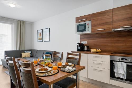 布拉迪斯拉发维尔戈公寓式酒店的厨房配有带食物和橙汁的桌子