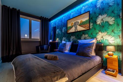 隆瑞莫Sunset Appart-Hotel 3 chambres, 2 Salles de Bain, proche Paris, Massy & Orly的一间卧室设有一张蓝色墙壁的大床