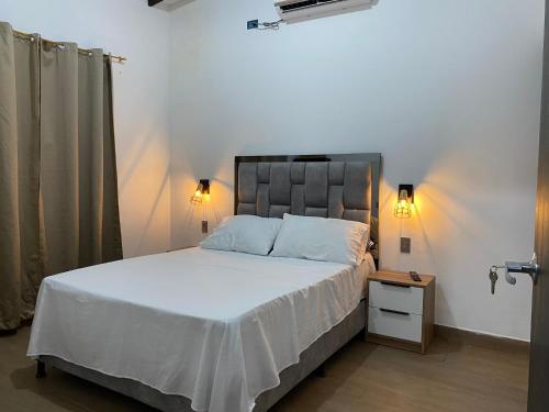 Punta de PiedraMalibu beach的一间卧室配有一张带白色床单的大床和床头柜