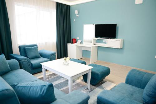 舒门Роял Шумен的客厅配有蓝色的沙发和电视