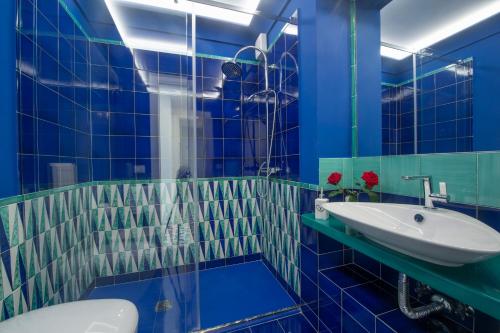 弗洛里La Perla di Nettuno的蓝色的浴室设有水槽和卫生间