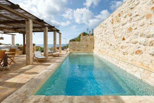 赫瓦尔Villa Vito的一座拥有石墙和蓝色海水的游泳池