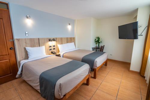 阿雷基帕Casa Villa Arequipa的酒店客房设有两张床和一台平面电视。