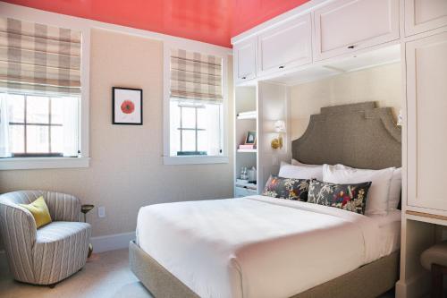波士顿毕肯山酒店的卧室配有一张白色大床和一把椅子