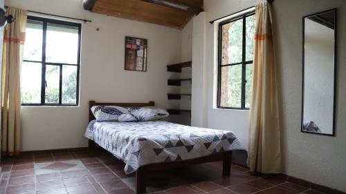 派帕Arte sin Fronteras Hostel的一间卧室设有一张床和两个窗户。