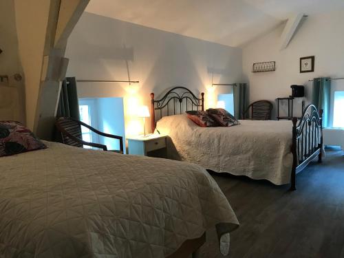 图阿尔MOULIN DE L'ABBESSE的一间卧室配有两张床和两把椅子