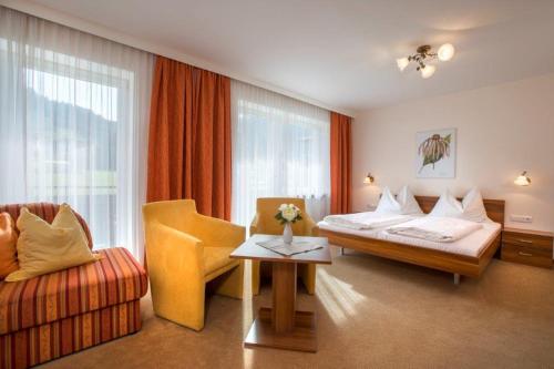 平茨高谷地霍勒尔斯巴赫Garni Rösslhof的配有一张床和一把椅子的酒店客房