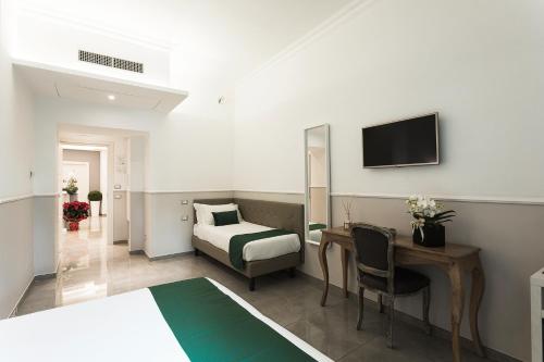 罗马梵蒂冈豪华宾馆 的酒店客房配有一张床、一张书桌和一台电视。