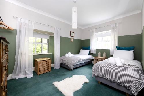 德里门Strathendrick House Magnificent property with Garden的绿白色客房内的两张床
