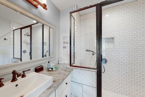 罗克波特Packsaddle Beach House的一间带水槽和玻璃淋浴的浴室