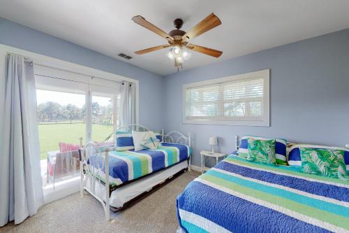 罗克波特Packsaddle Beach House的一间卧室配有两张床和吊扇
