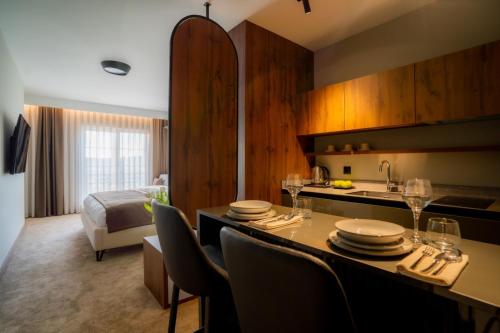 普里什蒂纳Downtown Apartments的酒店客房设有厨房和桌椅
