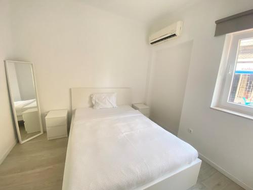 塞图巴尔Gama Apartment的白色的客房配有床和镜子
