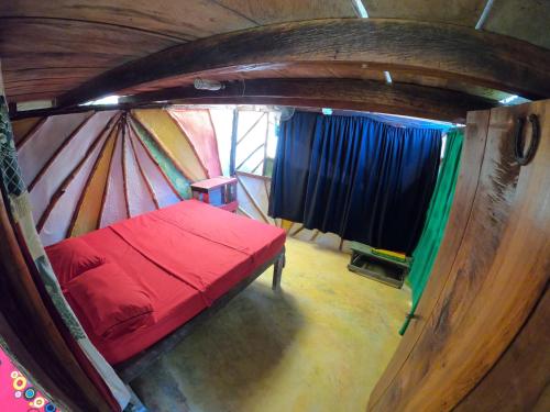卡普兰干Reciclarte Galería Hostal的圆顶帐篷内的一间小房间,配有一张红色的床