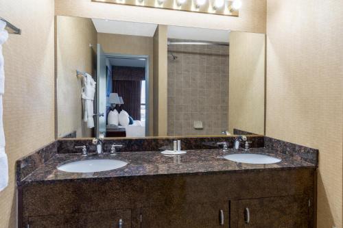 里诺Ramada by Wyndham Reno Hotel & Casino的一间带两个盥洗盆和大镜子的浴室
