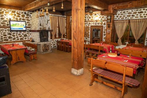 梅尔尼克Стария Чинар Мелник的一间带木桌和壁炉的用餐室
