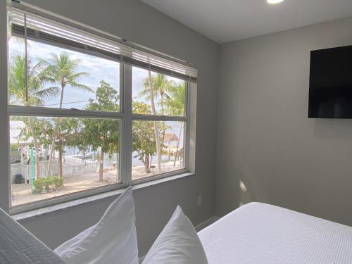 基拉戈Amoray Dive Resort的一间卧室设有一张床和一个大窗户