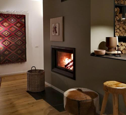 ProgledGORA уютна планинска къща до ски зона Пампорово的客厅的墙上设有壁炉