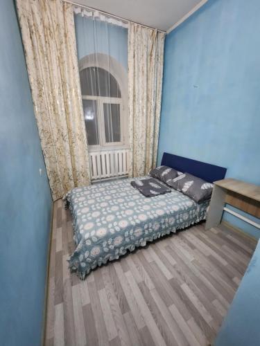 阿拉木图Оазис的一间卧室设有一张床和一个窗口