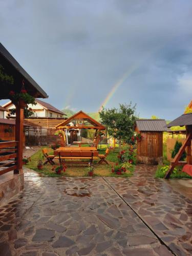 瓦杜伊泽Pensiunea Adriana的一个带长凳的庭院的背景彩虹