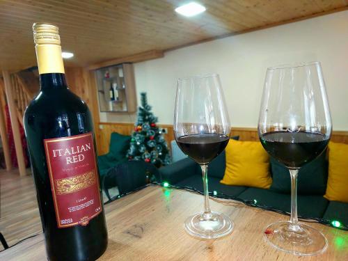 卡兹贝吉Hotel Garbani的木桌旁的两杯红葡萄酒