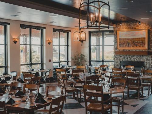 GeorgeSagecliffe Resort & Spa的用餐室设有桌椅和窗户。