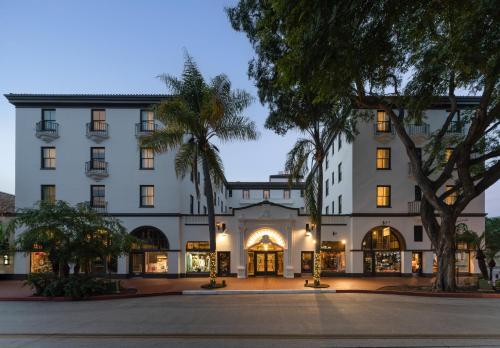 圣巴巴拉圣巴巴拉酒店的一座白色的大建筑,前面有棕榈树