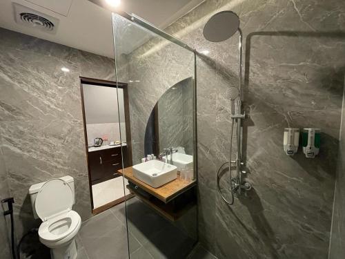 NgabeanOhana Suites Yogyakarta的浴室配有卫生间、盥洗盆和淋浴。