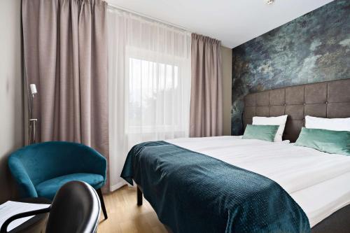 韦纳穆Best Western Hotel Vidöstern的卧室配有床、椅子和窗户。