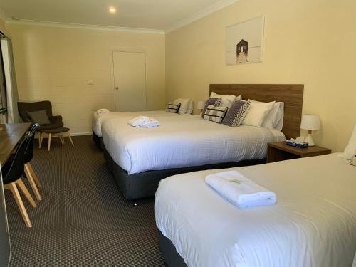 马奇Mudgee Vineyard Motor Inn的酒店客房配有两张床和一张书桌